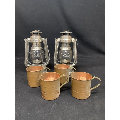 504 - Two hurricane lamps and four copper mugs