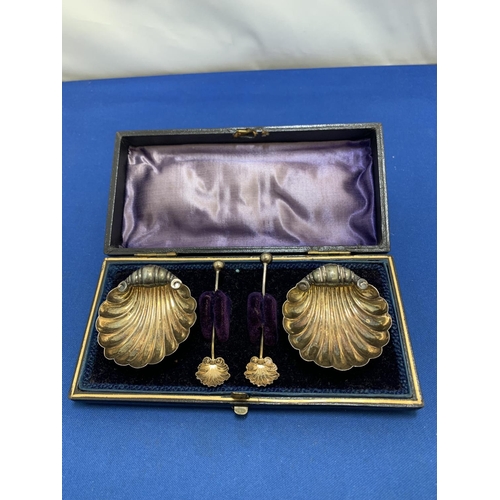 880 - Cased pair of Hallmarked Silver shell shaped salts and spoons, total weight .8 ozt