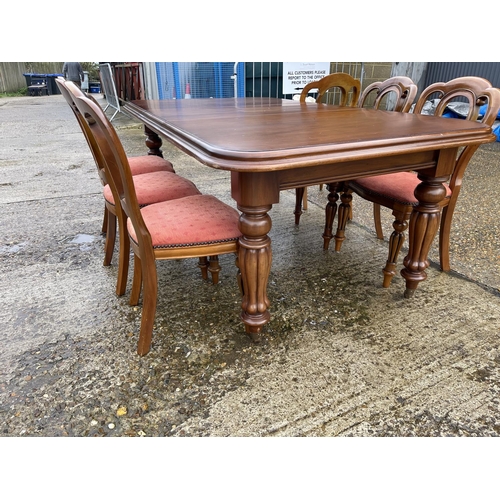 1 - A reproduction mahogany wind out dining table with one extension leaf, together with a set of six re... 