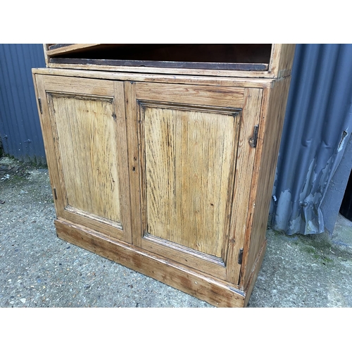 126 - A country pine bookcase cupboard with three adjusting shelves (lacking shelf pegs)