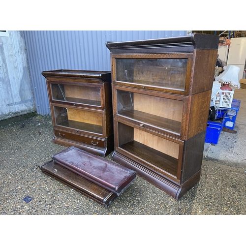 140 - Two early 20th century oak sectional bookcases by GUNN with glazed up and over doors (one glass MISS... 