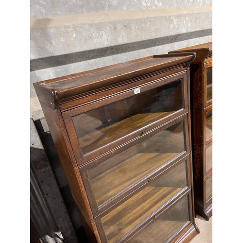 141 - An early 20th century four section oak bookcase with glazed up and over doors by GUNN