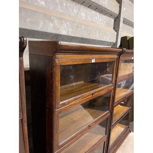 142 - An early 20th century four section oak bookcase with glazed up and over doors by GUNN