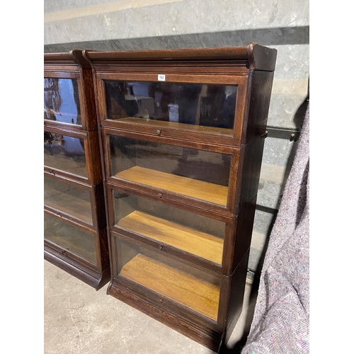 143 - An early 20th century four section oak bookcase with glazed up and over doors by GUNN