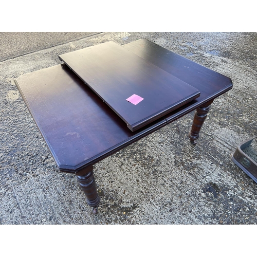 171 - An Edwardian mahogany dining table with extension leaf