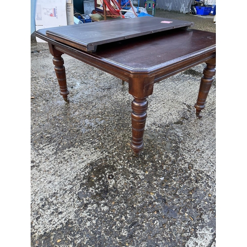 171 - An Edwardian mahogany dining table with extension leaf