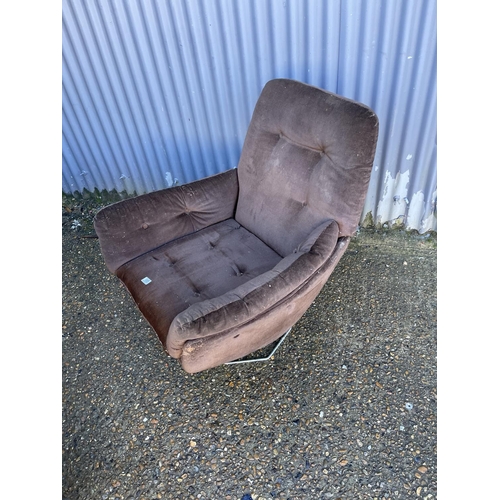 185 - A mid century brown upholstered swivel chair on chrome base