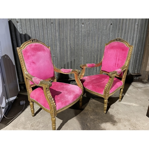 19 - A pair of gold gilt and pink upholstered throne style armchairs