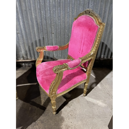19 - A pair of gold gilt and pink upholstered throne style armchairs