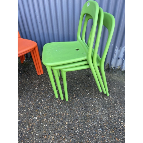 202 - Six green and orange stacking chairs