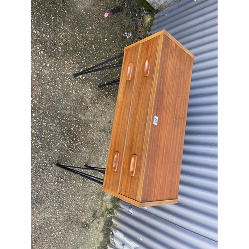 232 - A teak hall table / chest of two drawers raised on hairpin legs