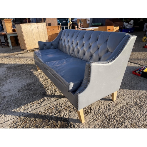 244 - A light blue leather chesterfield style buttoned sofa