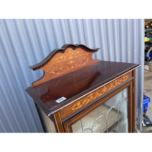 255 - An inlaid mahogany cabinet with leaded glass door