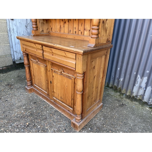 260 - A french pine dresser with open plate rack top over two drawer and two door base