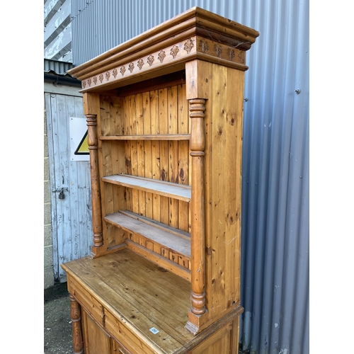 260 - A french pine dresser with open plate rack top over two drawer and two door base