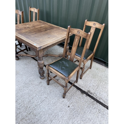 274 - An early 20th century oak drawer leaf table and four oak chairs