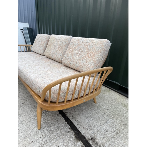 281 - An original ercol light elm day bed with web seat, removable plank back board and original cushion s... 