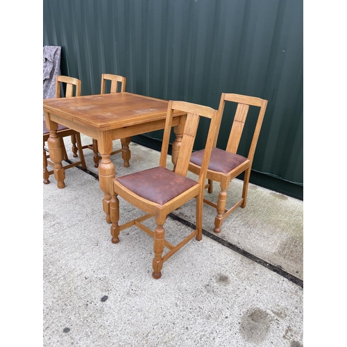 304 - An oak drawer leaf table and four chairs