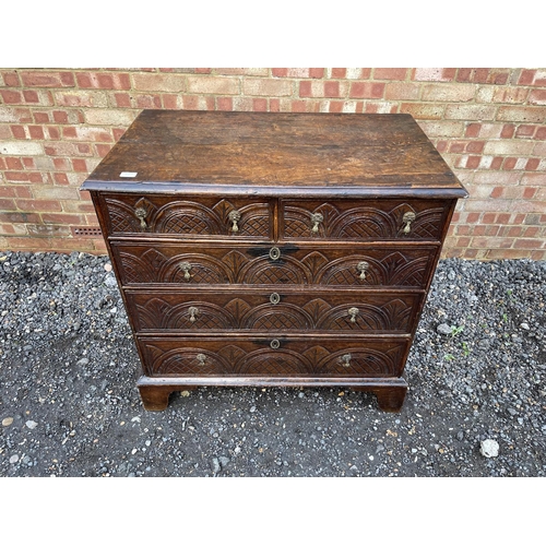 337 - An antique oak chest of five drawers carved to the front and fitted with brass drop handles