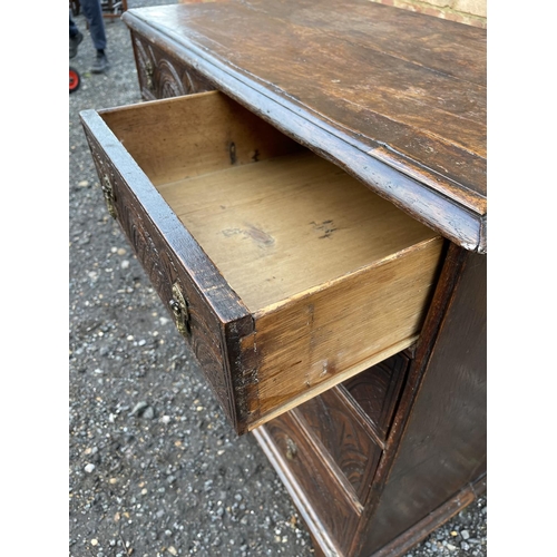 337 - An antique oak chest of five drawers carved to the front and fitted with brass drop handles