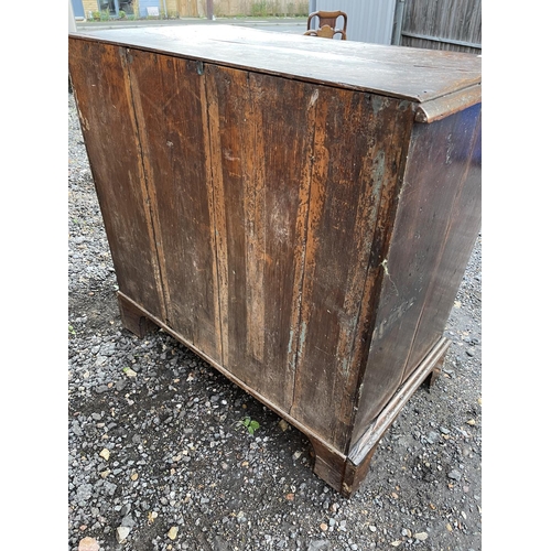 337 - An antique oak chest of five drawers carved to the front and fitted with brass drop handles