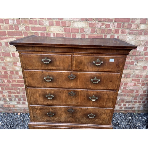 352 - A Georgian walnut chest of five drawers raised on two drawer stand