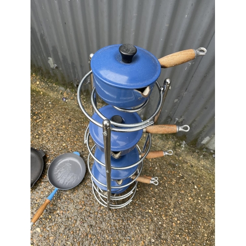 371 - A chrome pan stand loaded with a graduated set of LE CREUSET pans together with two frying pans