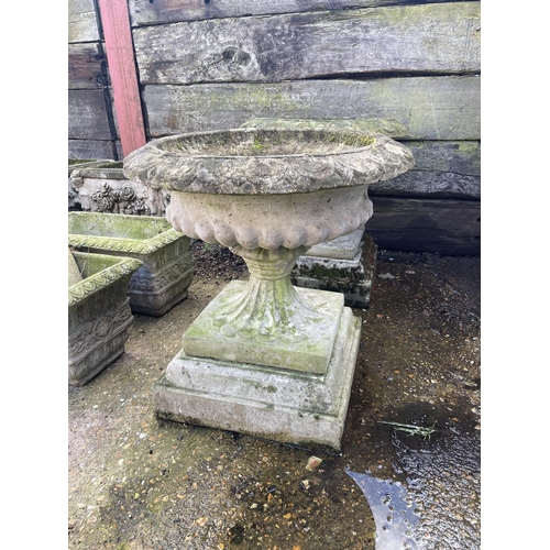 390 - A pair of large circular concrete pedestal urns, raised on square concre plinths 62 diameter. X 66hi... 