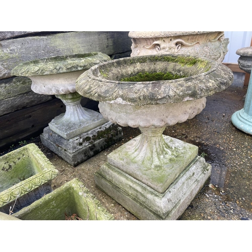 390 - A pair of large circular concrete pedestal urns, raised on square concre plinths 62 diameter. X 66hi... 