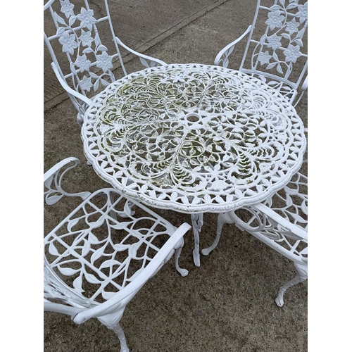 390b - A circular white painted aluminum garden table with four chairs