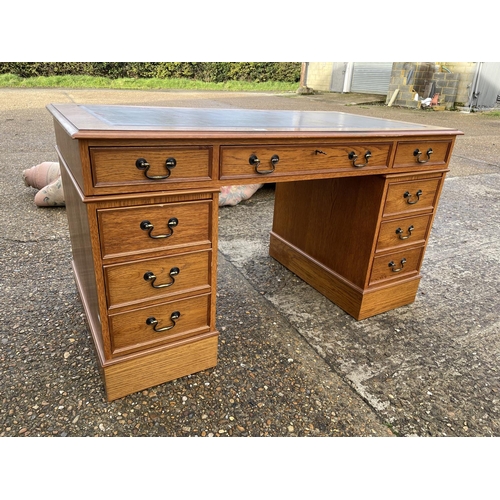 48 - A reproduction oak twin pedestal desk with a red leather top