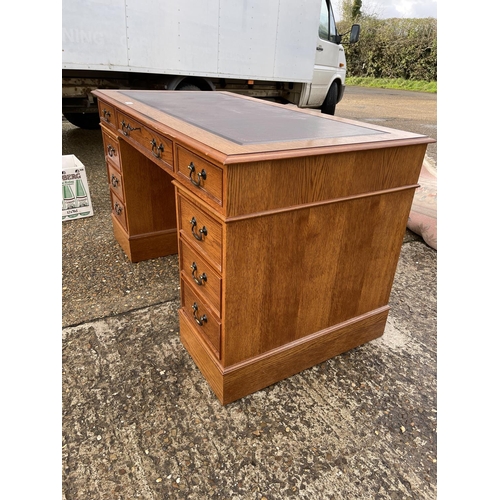 48 - A reproduction oak twin pedestal desk with a red leather top