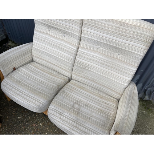 69 - A MODERN ERCOL upholstered two seater recliner sofa together with matching revolving armchair with s... 