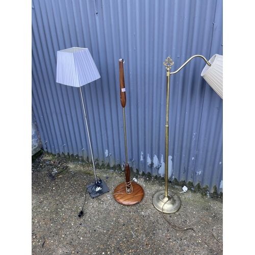 114 - A teak floor standing lamp together with two others