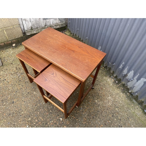 121 - A mid century teak trolley nest of three tables with fold over top