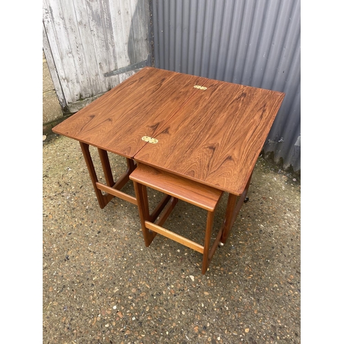 121 - A mid century teak trolley nest of three tables with fold over top