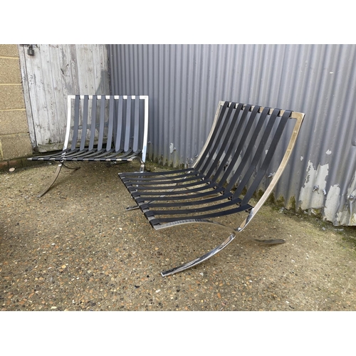 124 - A pair of chrome framed Barcelona chairs with cushions for reupholstery