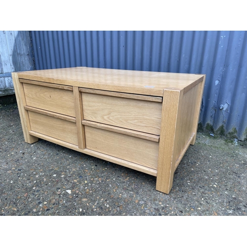 131 - A modern light oak four drawer coffee table 100x 60x50