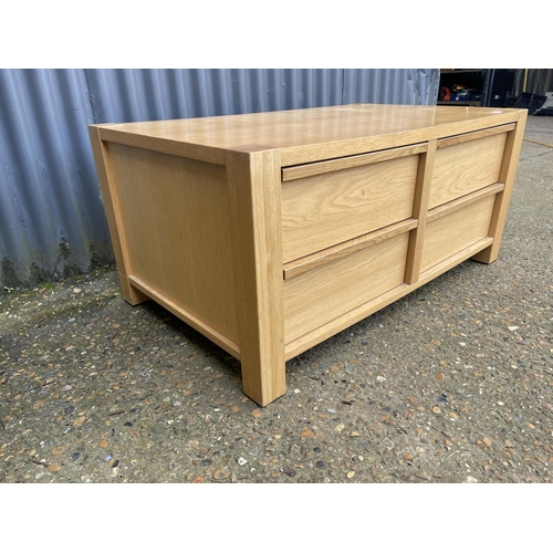 131 - A modern light oak four drawer coffee table 100x 60x50