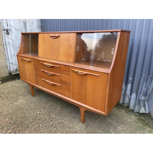 135 - A mid century teak sideboard with drop down cocktail compartment 167cm wide