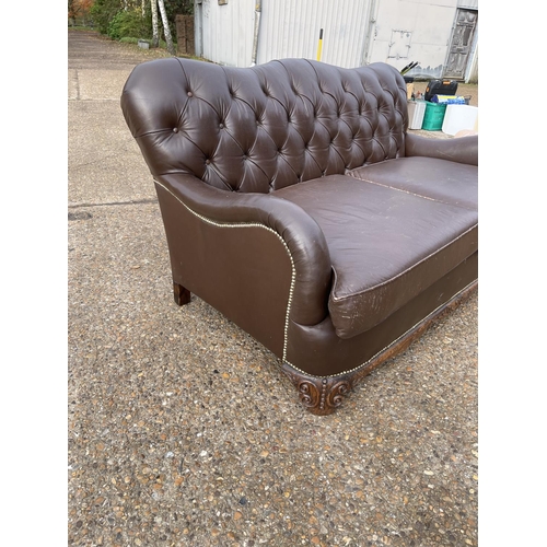 153 - A brown leather chesterfield club style two seat sofa