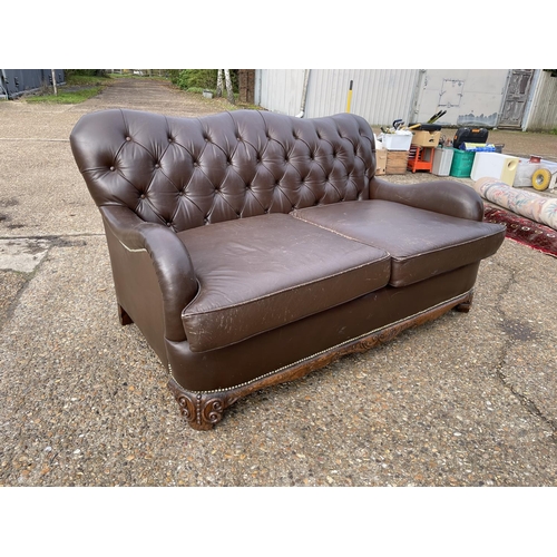 153 - A brown leather chesterfield club style two seat sofa