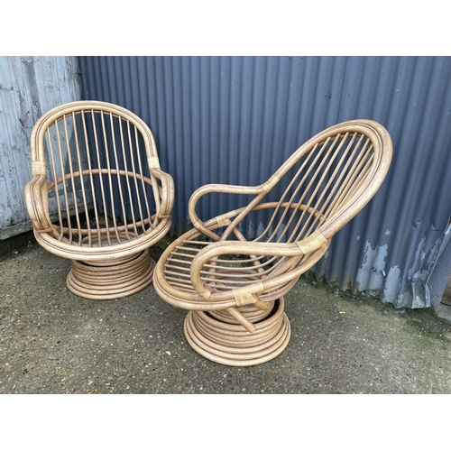 163 - A pair of 20th century bamboo swivel and spring bamboo lounger chairs