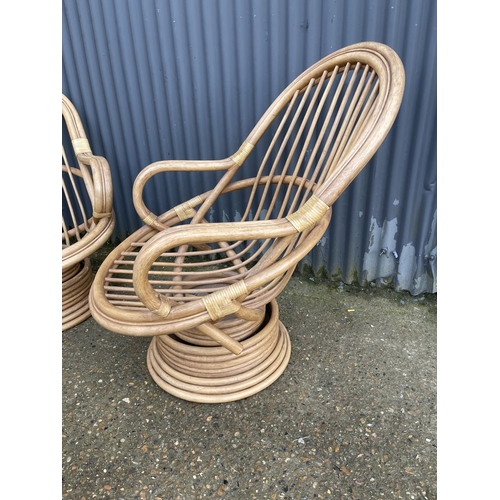 163 - A pair of 20th century bamboo swivel and spring bamboo lounger chairs