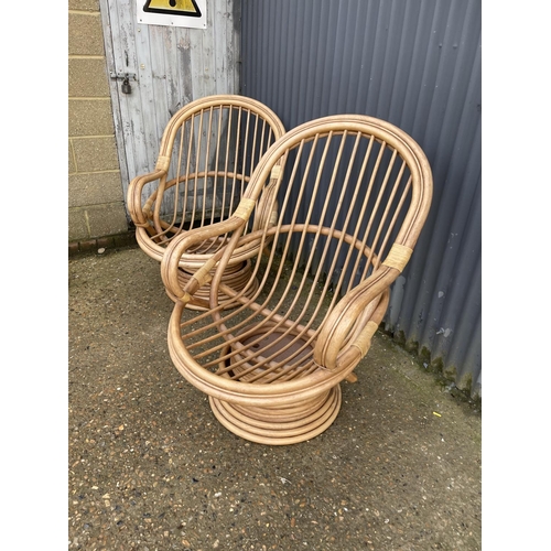 163 - A pair of 20th century bamboo swivel and spring bamboo lounger chairs