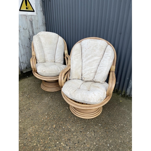 163 - A pair of 20th century bamboo swivel and spring bamboo lounger chairs