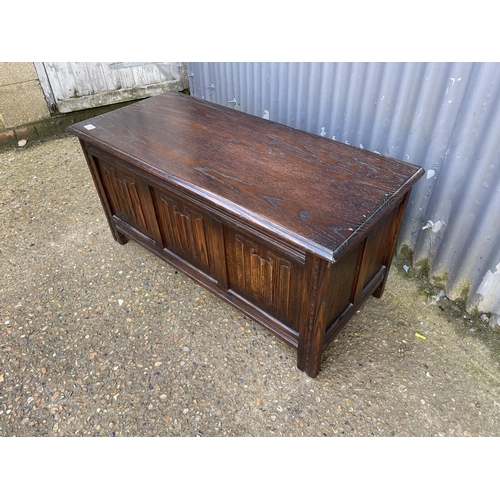 170 - A repro oak three panel coffer 107cm wide