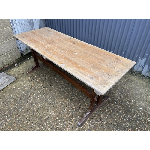 20 - A refectory style dining table with pine top and oak stretcher base 180x66x79