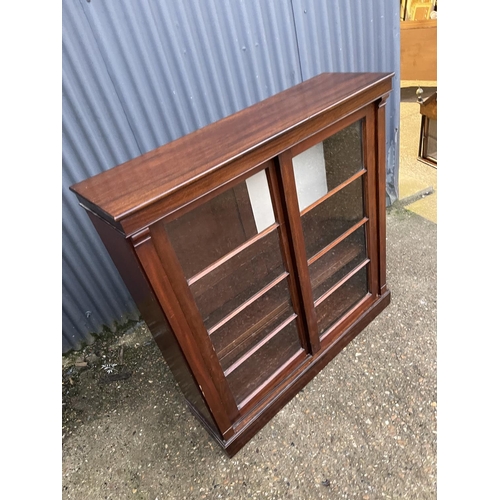 260 - A mahogany bookcase with ajdustable shelves and two glazed sliding doors