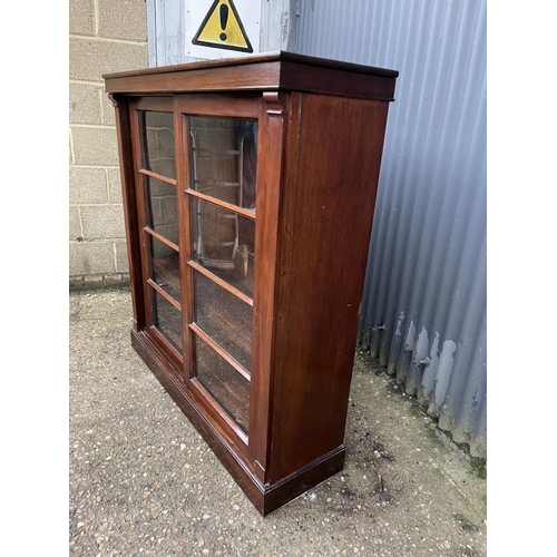 260 - A mahogany bookcase with ajdustable shelves and two glazed sliding doors